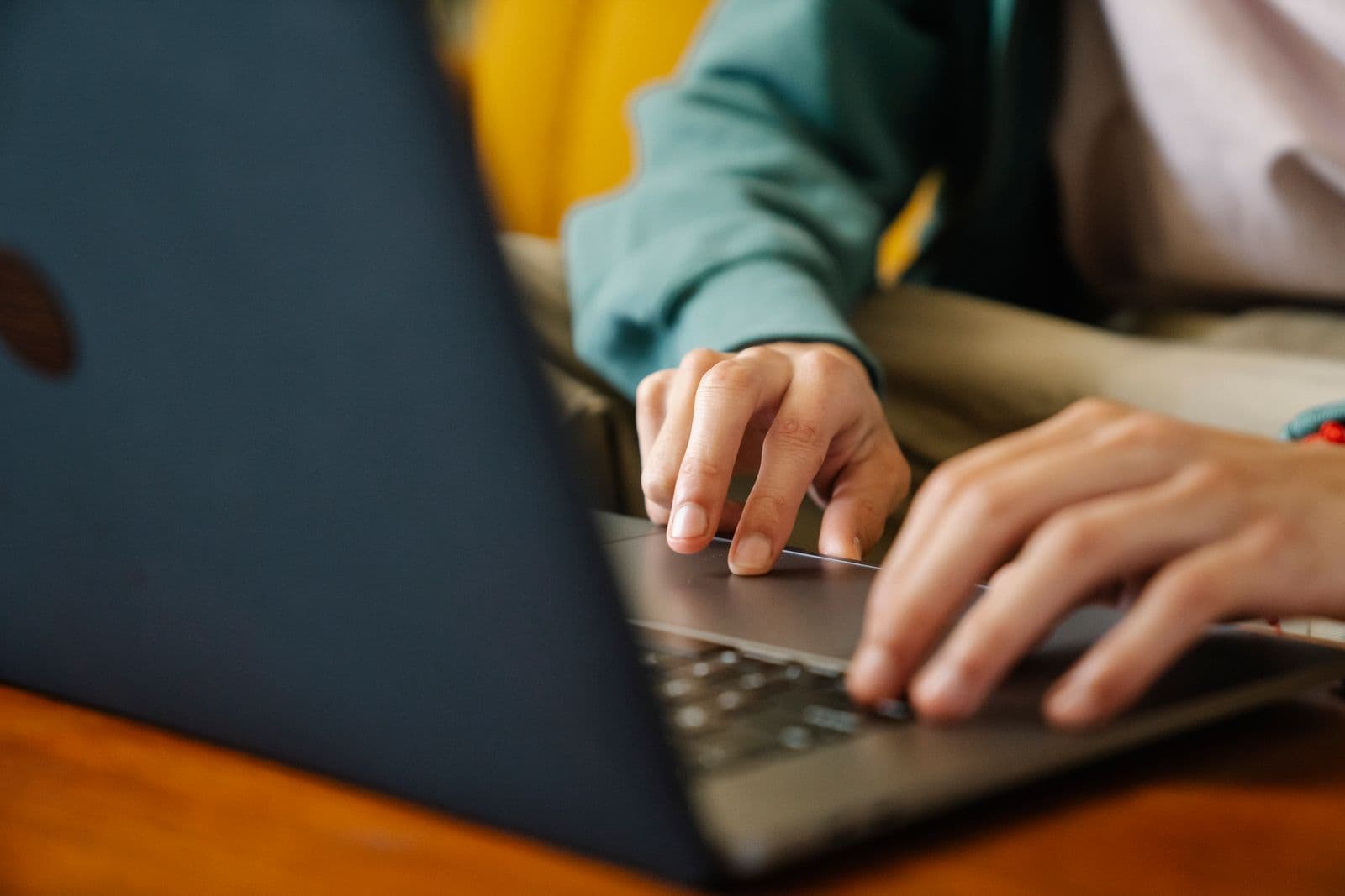 Hands typing on a laptop keyboard