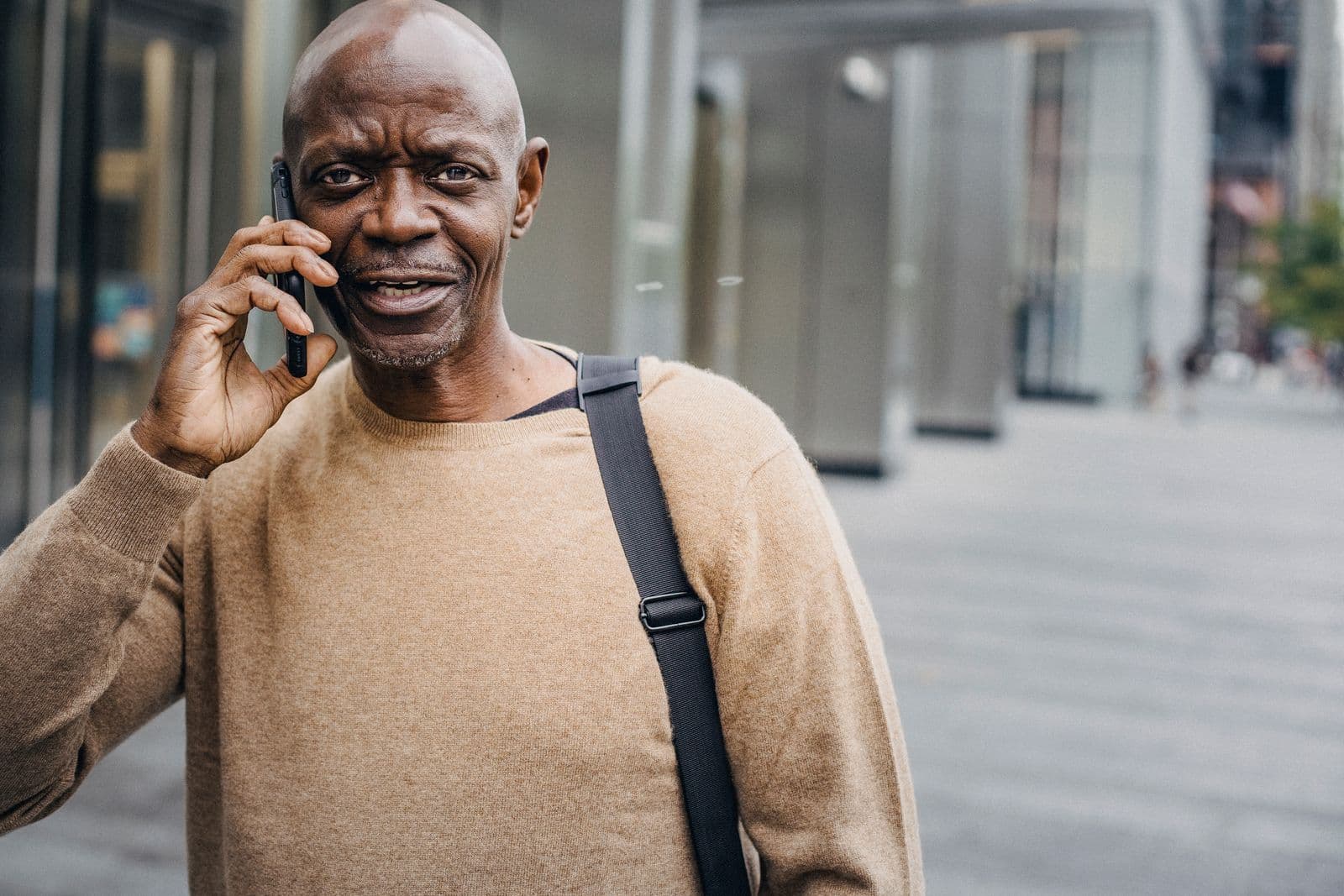 A person taking a call on a busy street